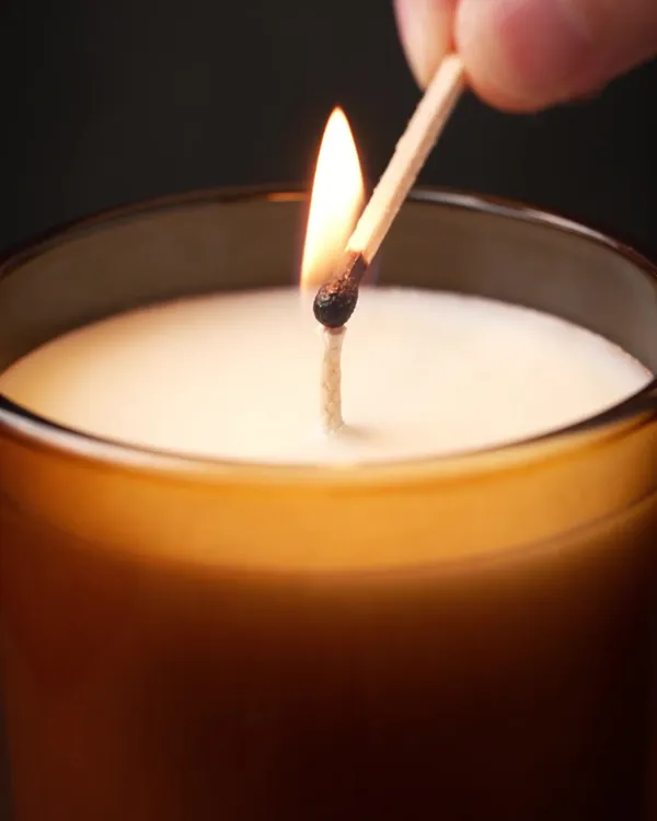 Free photo example: a hand lights the candle with a match